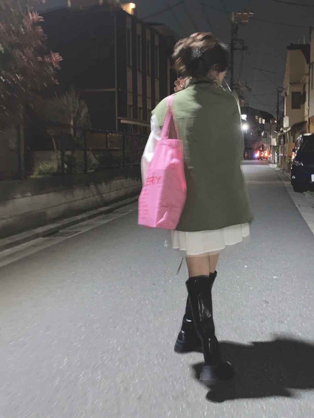 ブラック系のブーツ、グリーン系のミリタリージャケット、ホワイト系のワンピースを着用したレディースの春コーディネートの2枚目の写真