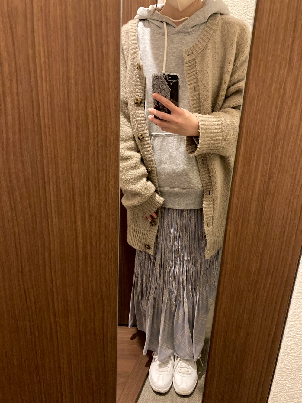 ホワイト系のスニーカー、ブルー系のスカート、ベージュ系のカーディガン/ボレロを着用したレディースの春コーディネートの2枚目の写真