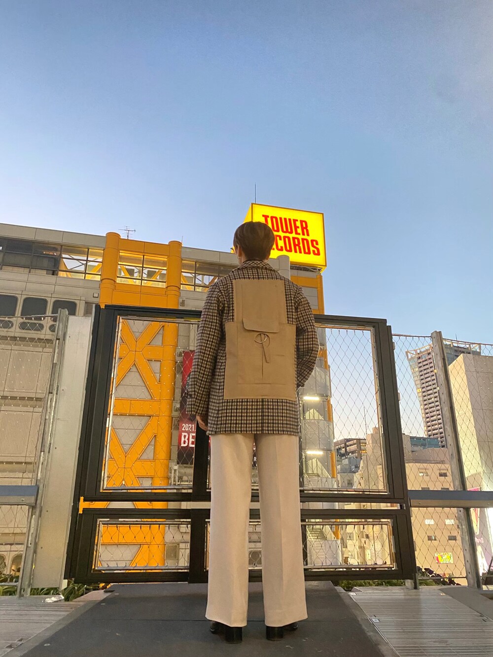 ブラウン系のジャケット/アウター、ホワイト系のスラックス、ブラック系のブーツを着用したメンズの冬コーディネートの2枚目の写真