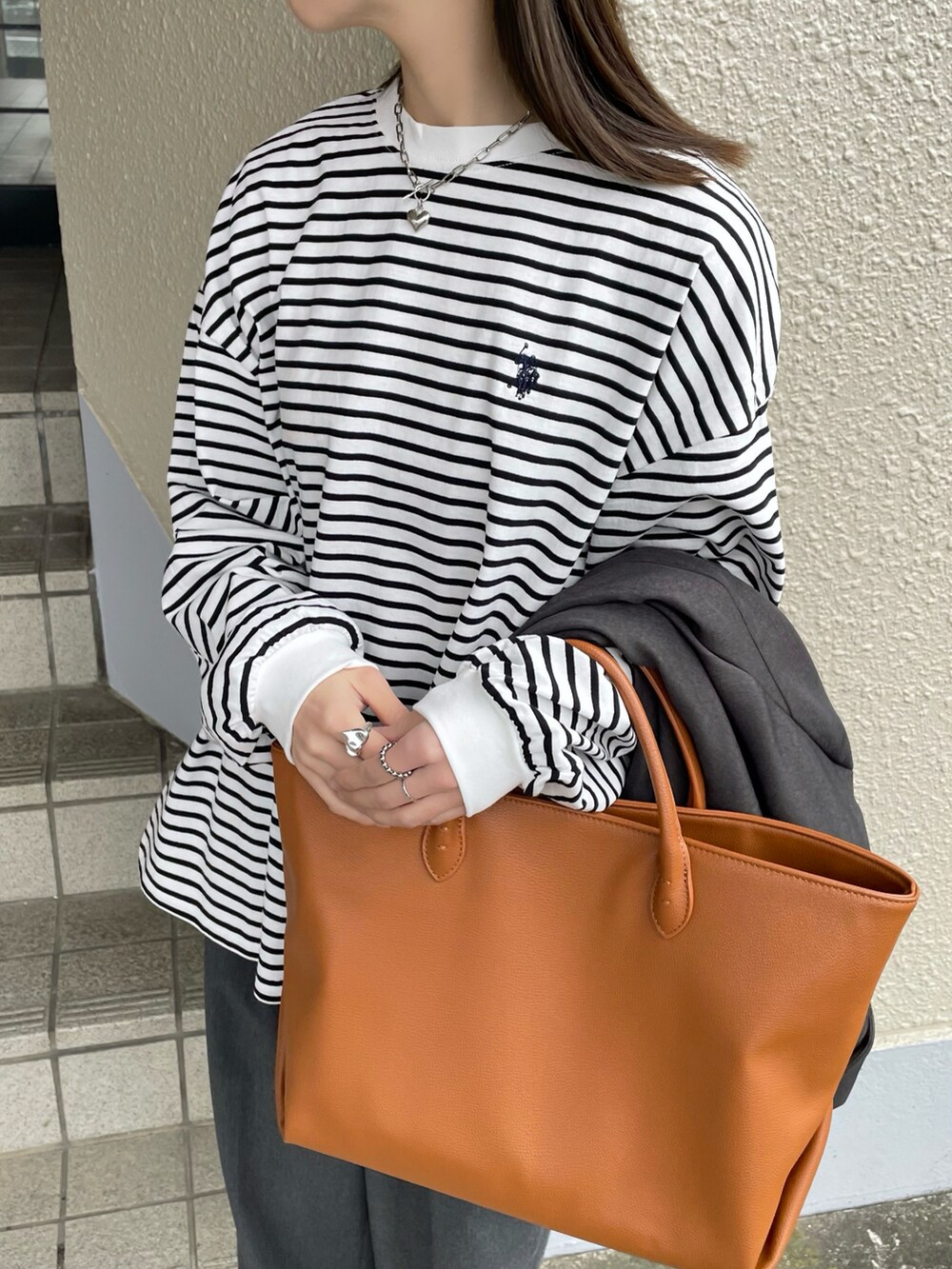 ホワイト系のTシャツ/カットソー、グレー系のスラックス、グレー系のテーラードジャケットを着用したレディースの冬コーディネートの2枚目の写真