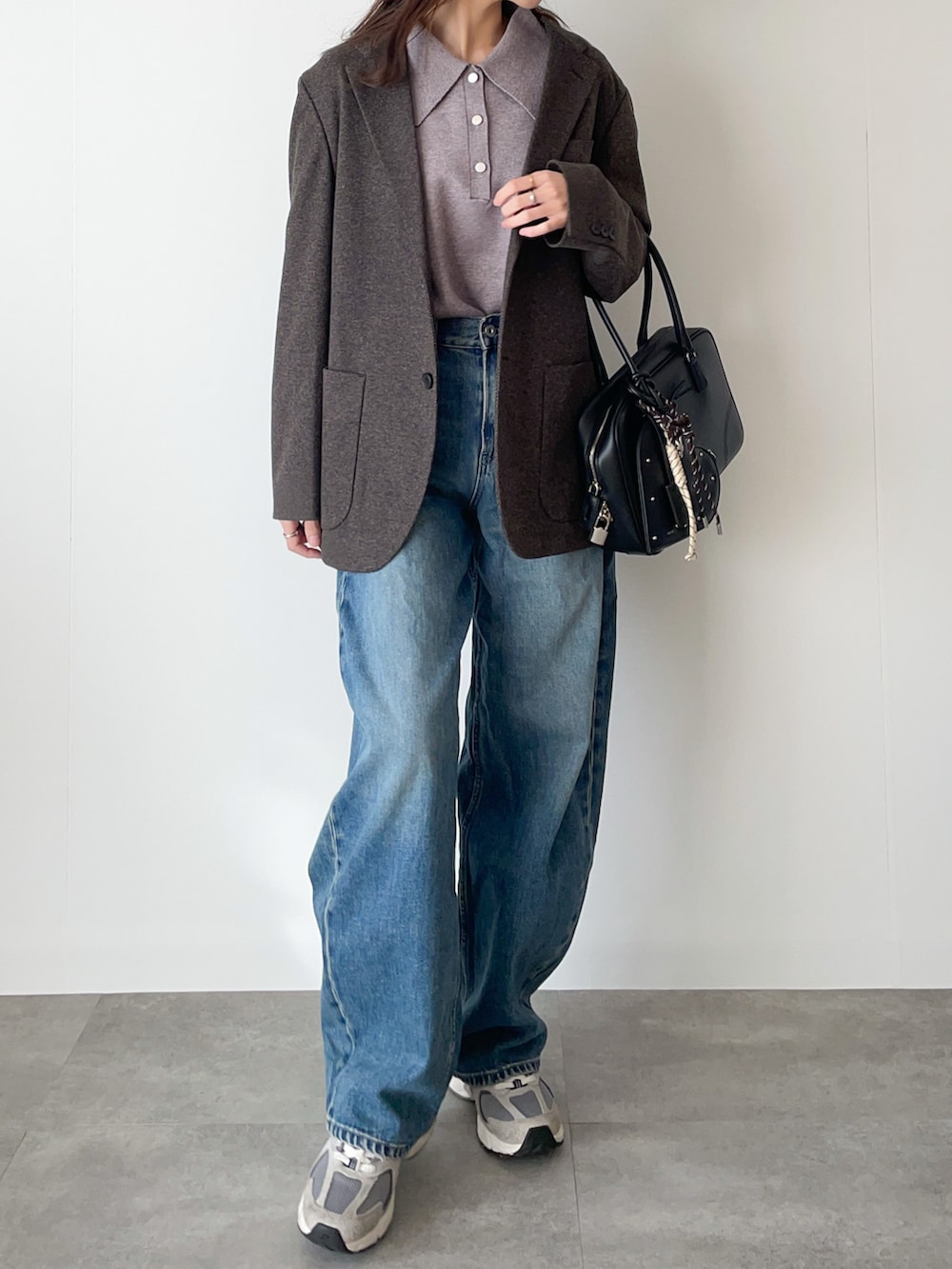 グレー系のニット/セーター、ブルー系のデニムパンツ、ブラック系のボストンバッグを着用したレディースの冬コーディネートの2枚目の写真