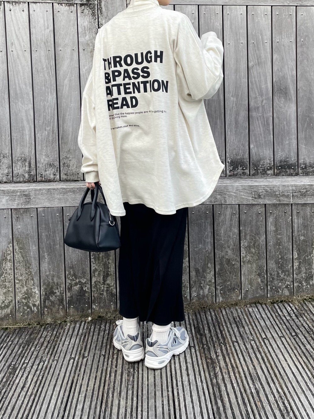 ホワイト系のスウェット、ブラック系のスカート、ブラック系のボストンバッグを着用したレディースの春コーディネートの2枚目の写真