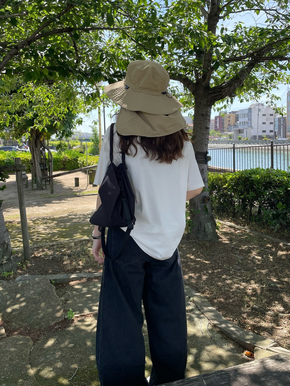 ホワイト系のTシャツ/カットソー、ブラック系のデニムパンツ、ベージュ系のハットを着用したレディースの夏コーディネートの2枚目の写真