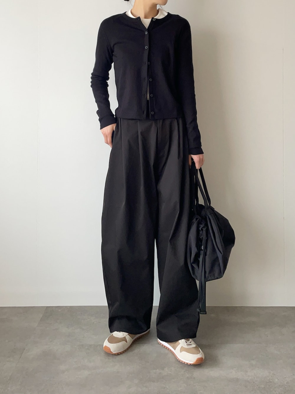 ブラック系のその他パンツ、ブラック系のバッグ、ベージュ系のスニーカーを着用したレディースの春コーディネートの2枚目の写真