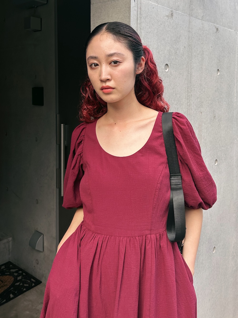 レッド系のワンピース、グリーン系のブーツを着用したレディースの夏コーディネートの2枚目の写真