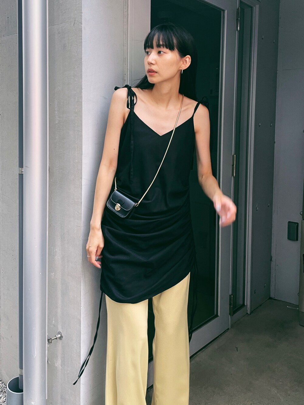 ブラック系のワンピース、イエロー系のその他パンツ、ホワイト系のパンプスを着用したレディースの夏コーディネートの4枚目の写真