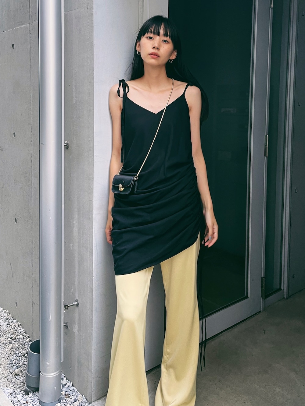 ブラック系のワンピース、イエロー系のその他パンツ、ホワイト系のパンプスを着用したレディースの夏コーディネートの3枚目の写真