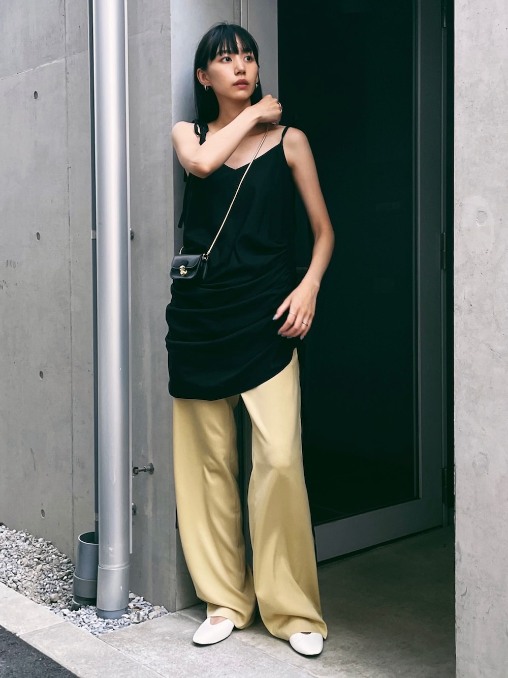 ブラック系のワンピース、イエロー系のその他パンツ、ホワイト系のパンプスを着用したレディースの夏コーディネートの2枚目の写真