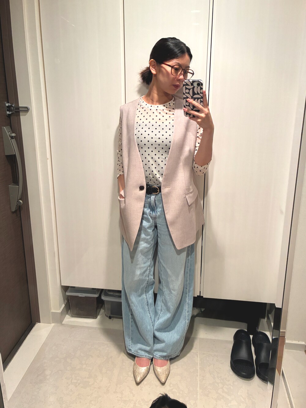 ブルー系のデニムパンツ、ベージュ系のベスト、ホワイト系のシャツ/ブラウスを着用したレディースの夏コーディネートの2枚目の写真