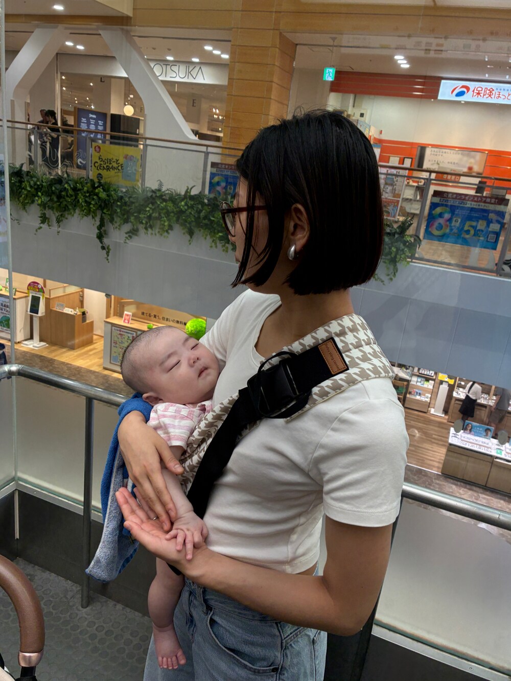 ブルー系のデニムパンツ、ブルー系のデニムジャケット、ブラック系のサンダルを着用したレディースの夏コーディネートの2枚目の写真