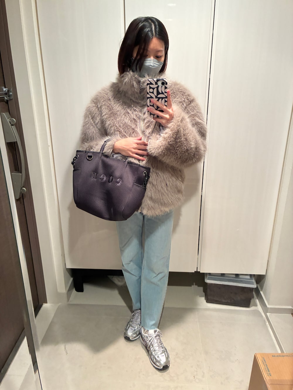 ベージュ系のその他アウター、ブルー系のデニムパンツ、シルバー系のスニーカーを着用したレディースの春コーディネートの2枚目の写真