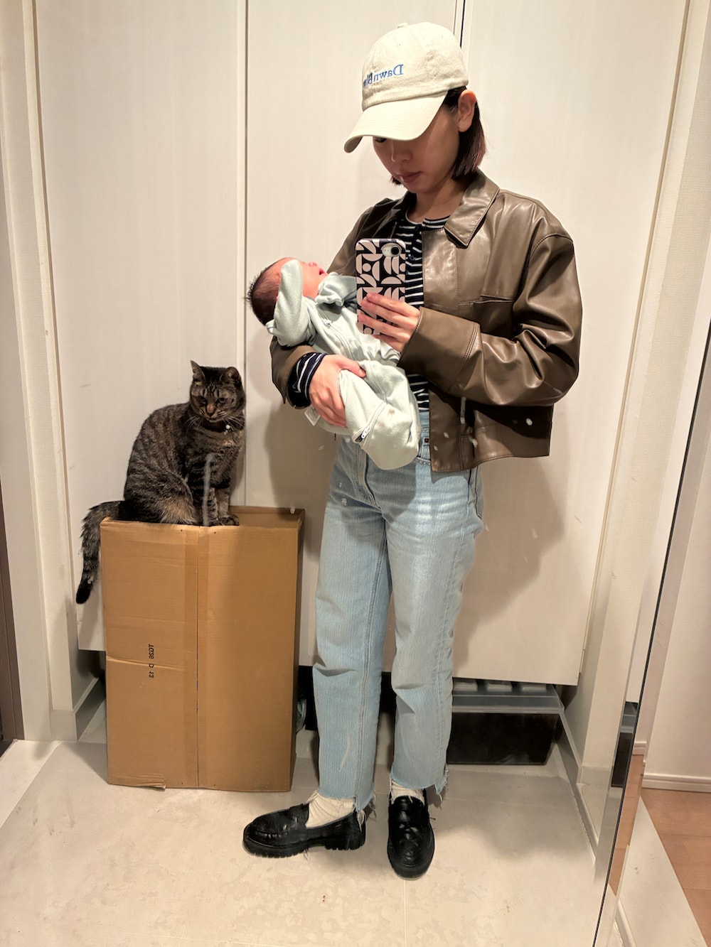 ブラウン系のブルゾン、ブルー系のデニムパンツ、ブラック系のローファーを着用したレディースの春コーディネートの2枚目の写真