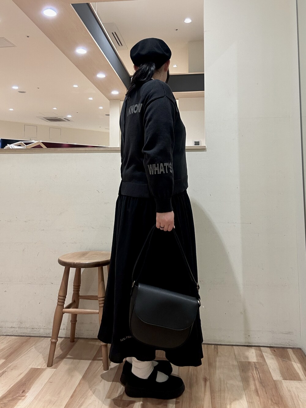 ブラック系のハンドバッグ、ブラック系のスカート、ブラック系のスニーカーを着用したレディースの春コーディネートの2枚目の写真