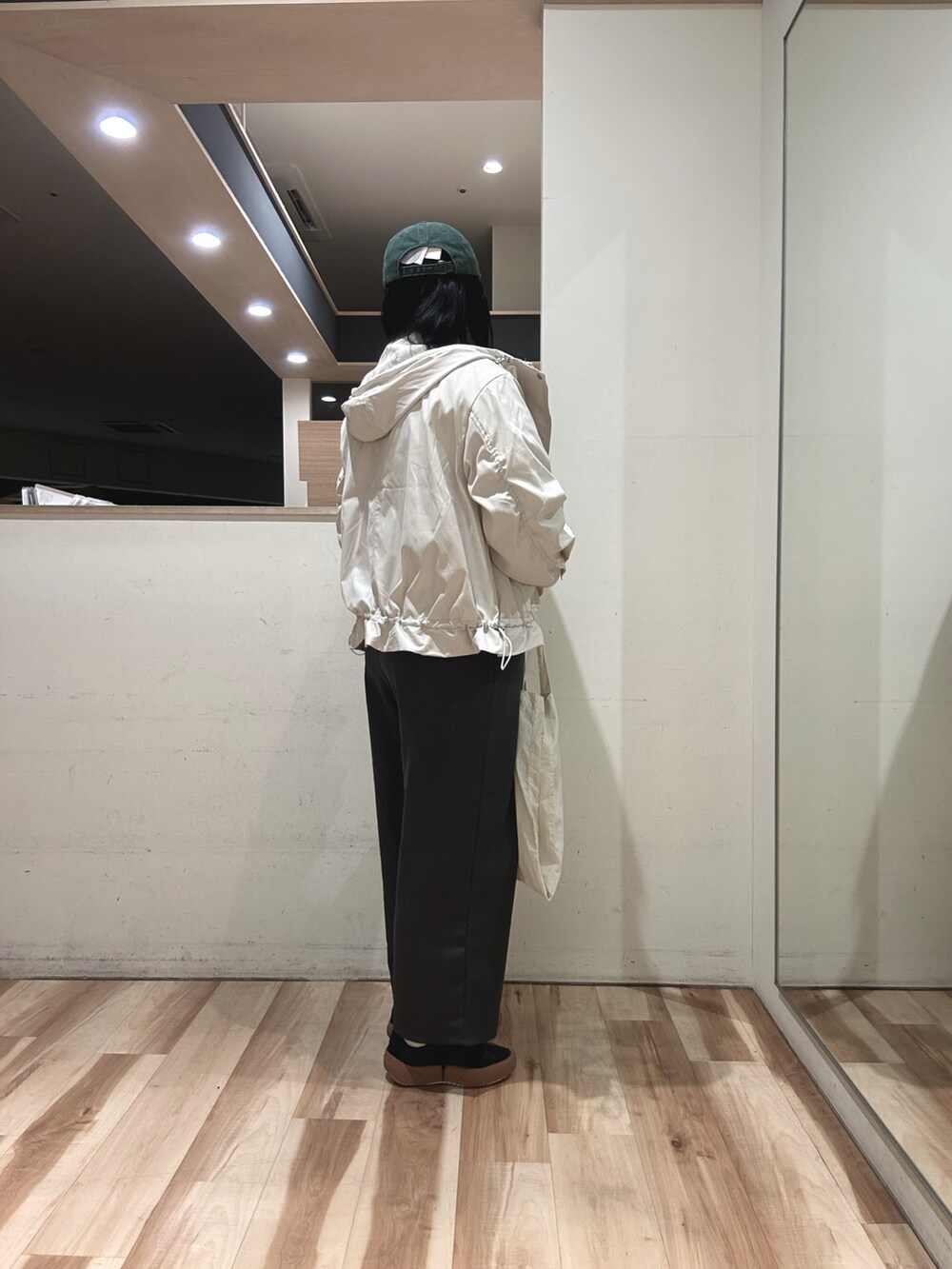 ホワイト系のTシャツ/カットソー、ホワイト系のブルゾン、ホワイト系のハンドバッグを着用したレディースの冬コーディネートの2枚目の写真