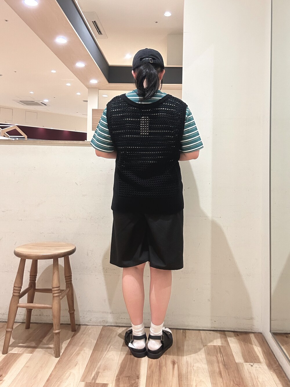 ブラック系のベスト、グリーン系のTシャツ/カットソー、ブラック系のその他パンツを着用したレディースの春コーディネートの3枚目の写真