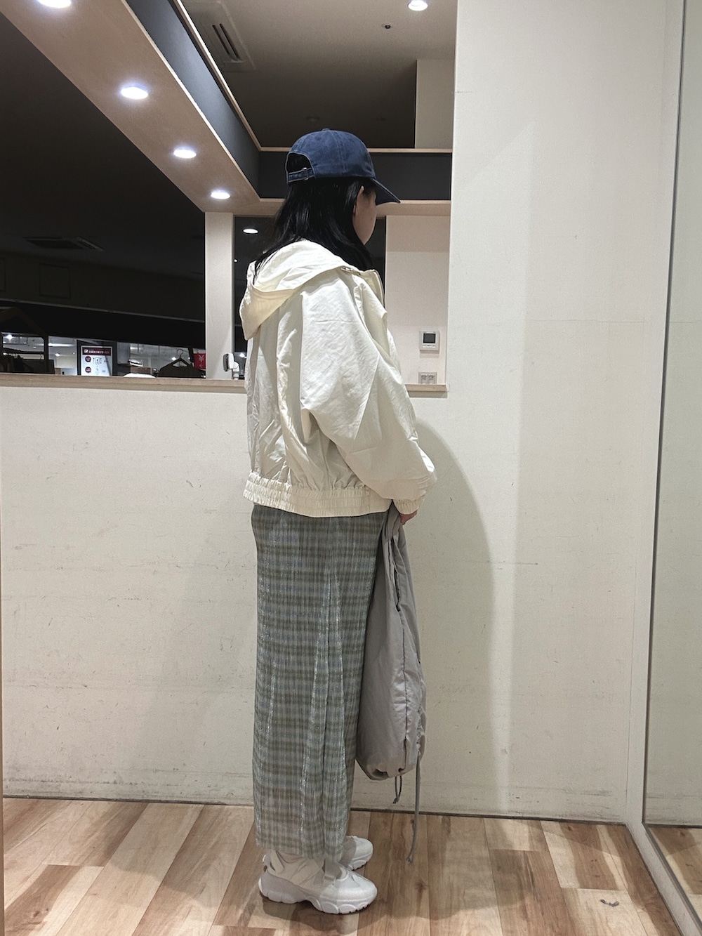 グレー系のハンドバッグ、ホワイト系のドレスシューズ、ホワイト系のブルゾンを着用したレディースの春コーディネートの2枚目の写真