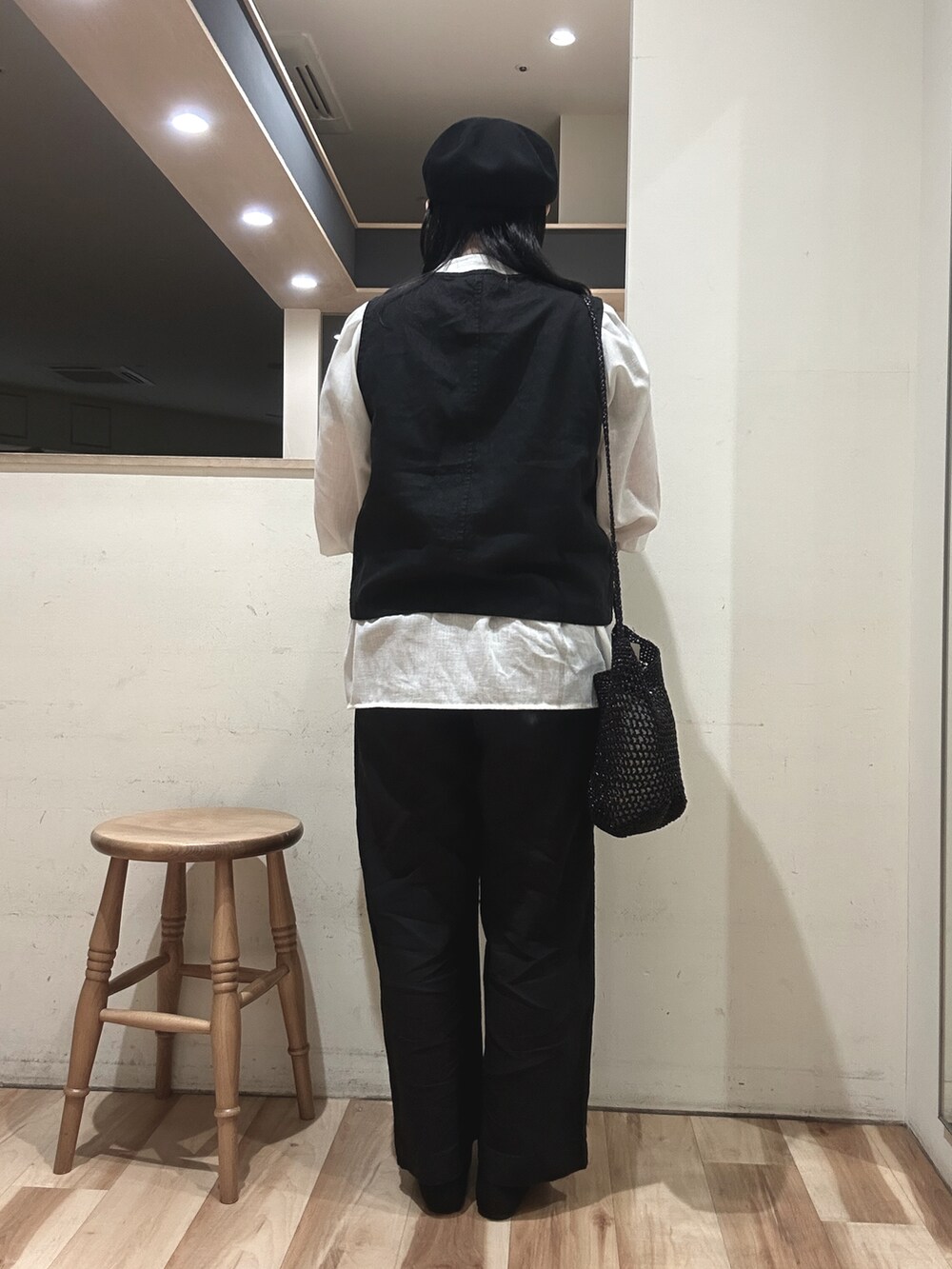 ブラック系のハンドバッグ、ブラック系のベスト、ホワイト系のシャツ/ブラウスを着用したレディースの春コーディネートの3枚目の写真