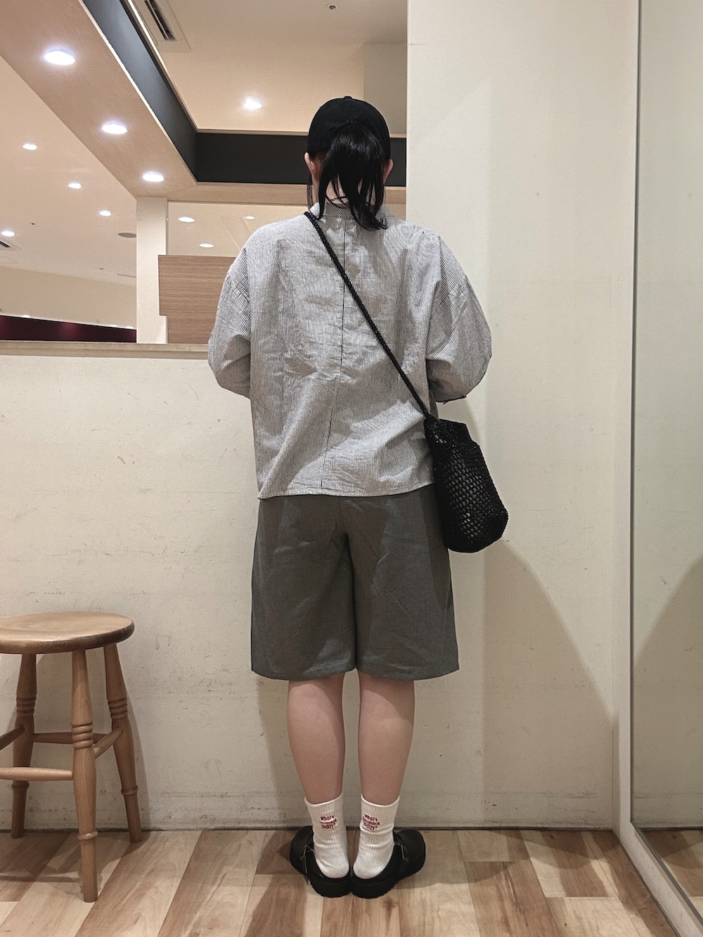 ブラック系のドレスシューズ、ブラック系のハンドバッグ、ブルー系のシャツ/ブラウスを着用したレディースの春コーディネートの3枚目の写真