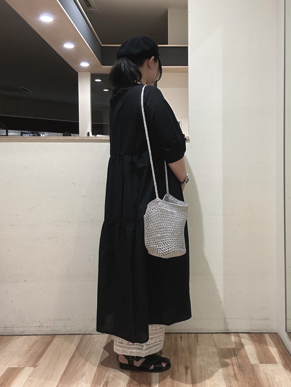 シルバー系のハンドバッグ、ブラック系のサンダル、ホワイト系のその他パンツを着用したレディースの春コーディネートの2枚目の写真