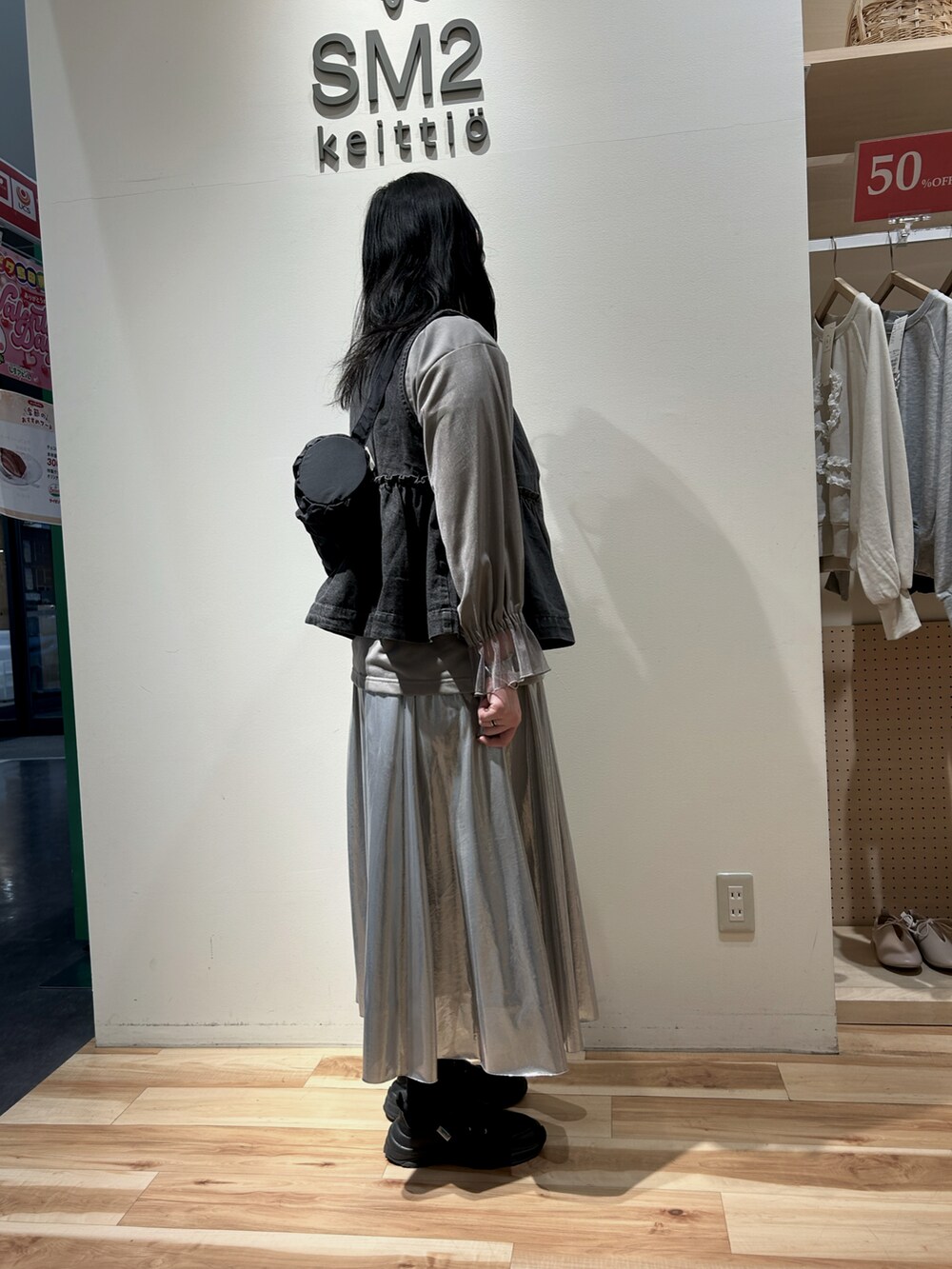 グレー系のTシャツ/カットソー、シルバー系のスカート、グレー系のベストを着用したレディースの冬コーディネートの2枚目の写真