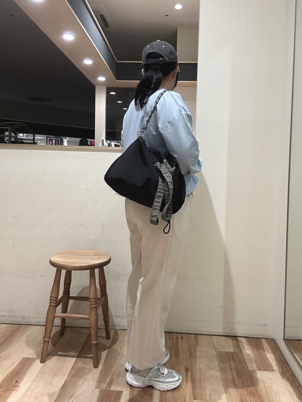 ブラック系のハンドバッグ、シルバー系のドレスシューズ、ブルー系のTシャツ/カットソーを着用したレディースの春コーディネートの2枚目の写真