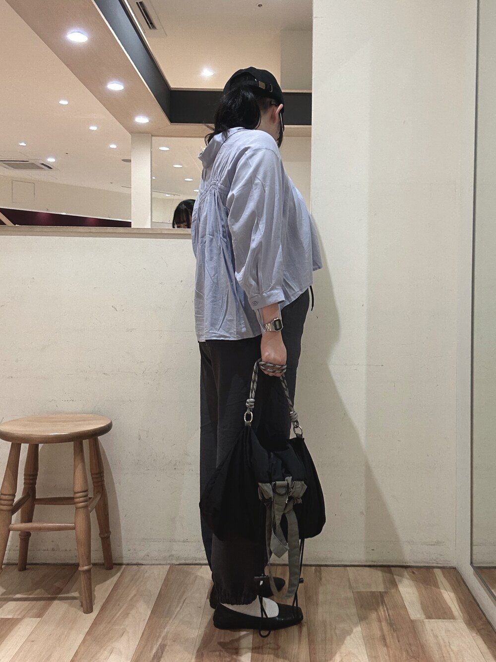 グレー系のその他パンツ、ブラック系のハンドバッグ、ブルー系のシャツ/ブラウスを着用したレディースの春コーディネートの2枚目の写真