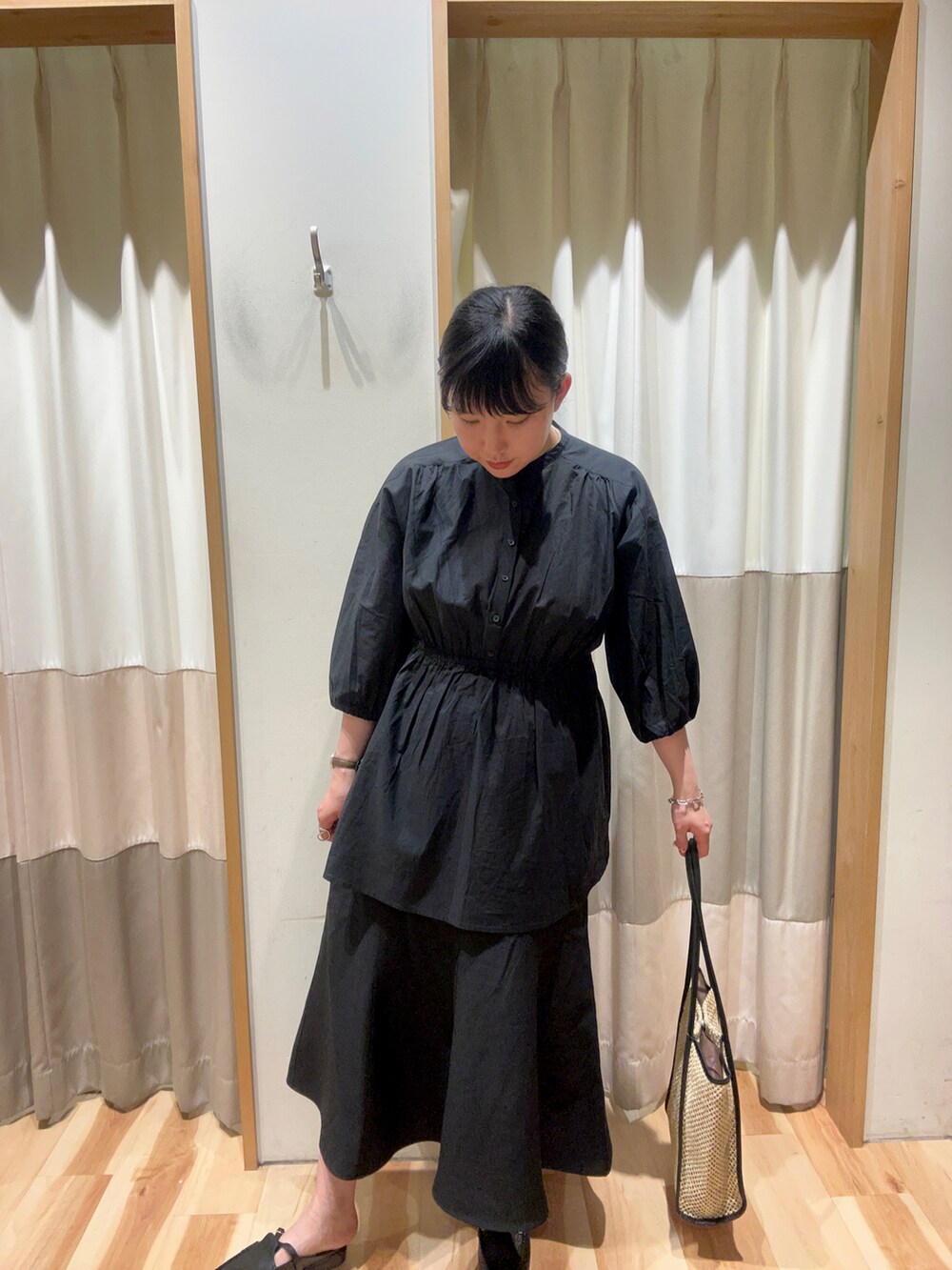 ブラック系のハンドバッグ、ブラック系のドレスシューズ、ブラック系のシャツ/ブラウスを着用したレディースの春コーディネートの2枚目の写真