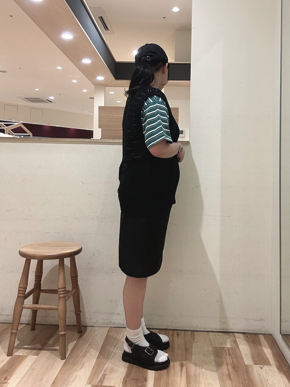 ブラック系のベスト、グリーン系のTシャツ/カットソー、ブラック系のその他パンツを着用したレディースの春コーディネートの2枚目の写真