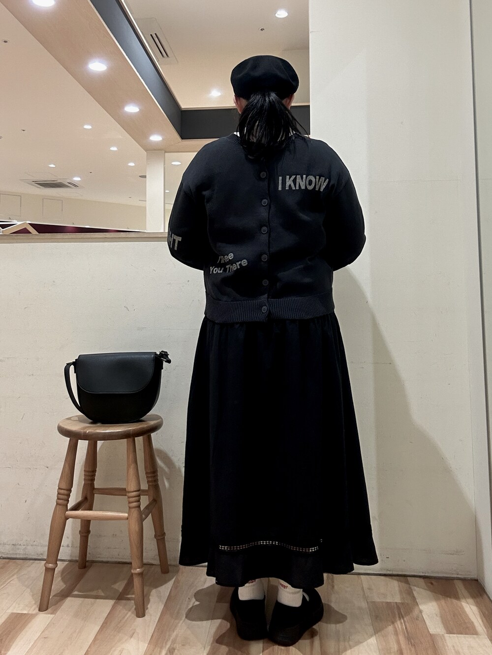 ブラック系のハンドバッグ、ブラック系のスカート、ブラック系のスニーカーを着用したレディースの春コーディネートの3枚目の写真