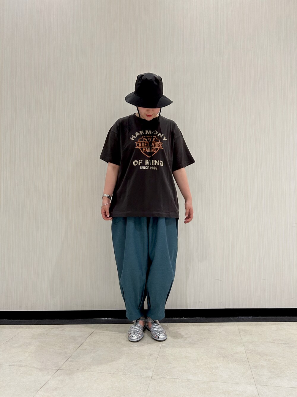 グレー系のTシャツ/カットソー、グリーン系のその他パンツ、シルバー系のサンダルを着用したレディースの夏コーディネートの2枚目の写真