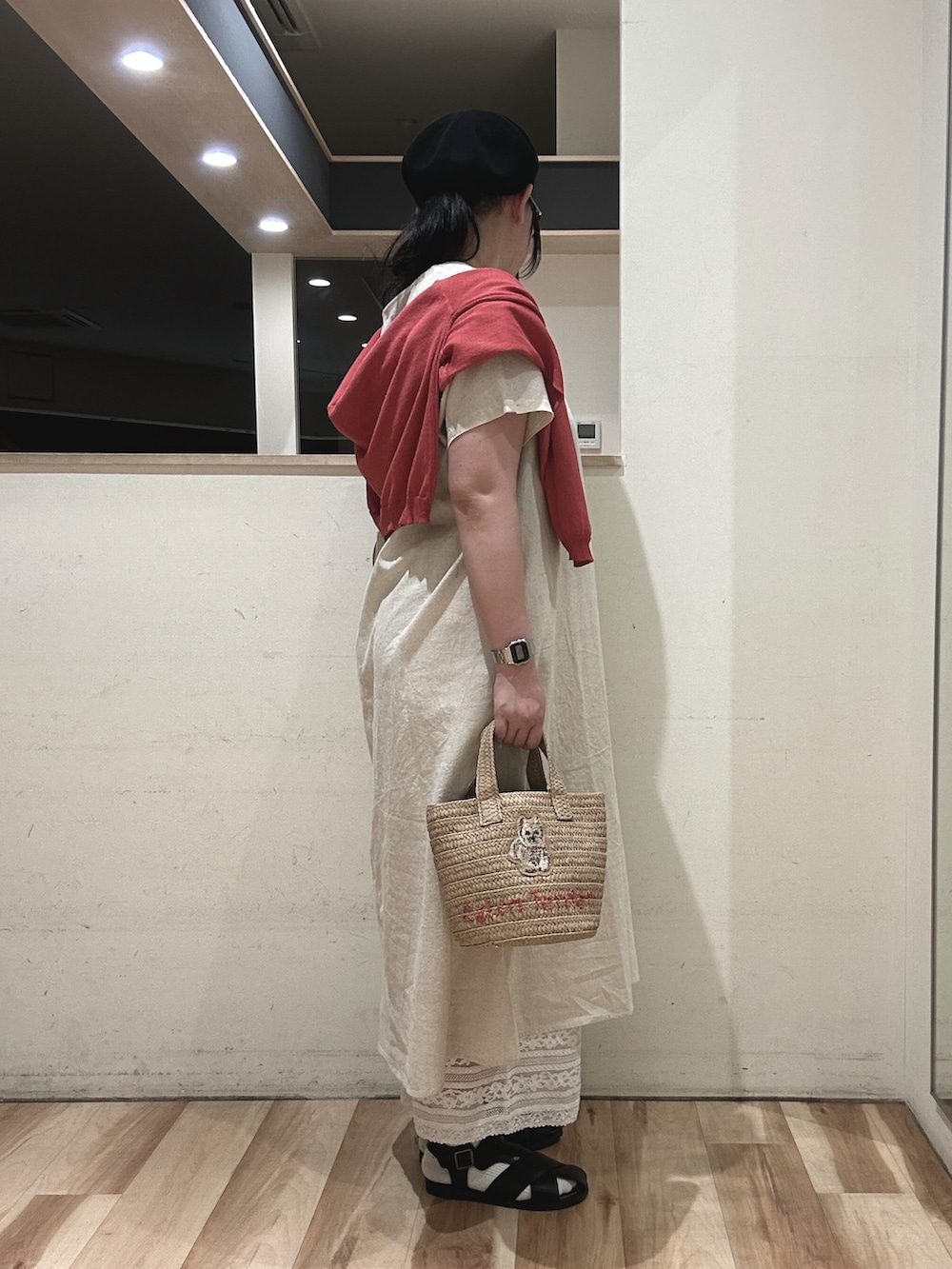 ホワイト系のハンドバッグ、ブラック系のサンダル、レッド系のカーディガン/ボレロを着用したレディースの春コーディネートの2枚目の写真