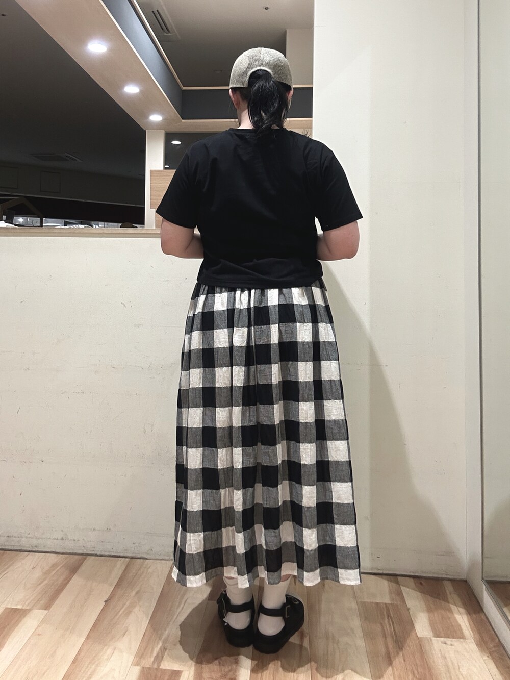 シルバー系のハンドバッグ、ブラック系のスカート、ブラック系のTシャツ/カットソーを着用したレディースの春コーディネートの2枚目の写真