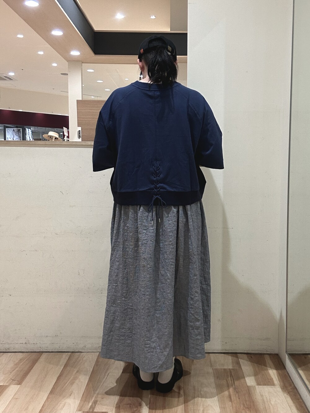 ホワイト系のハンドバッグ、ブラック系のドレスシューズ、ブルー系のスカートを着用したレディースの春コーディネートの3枚目の写真