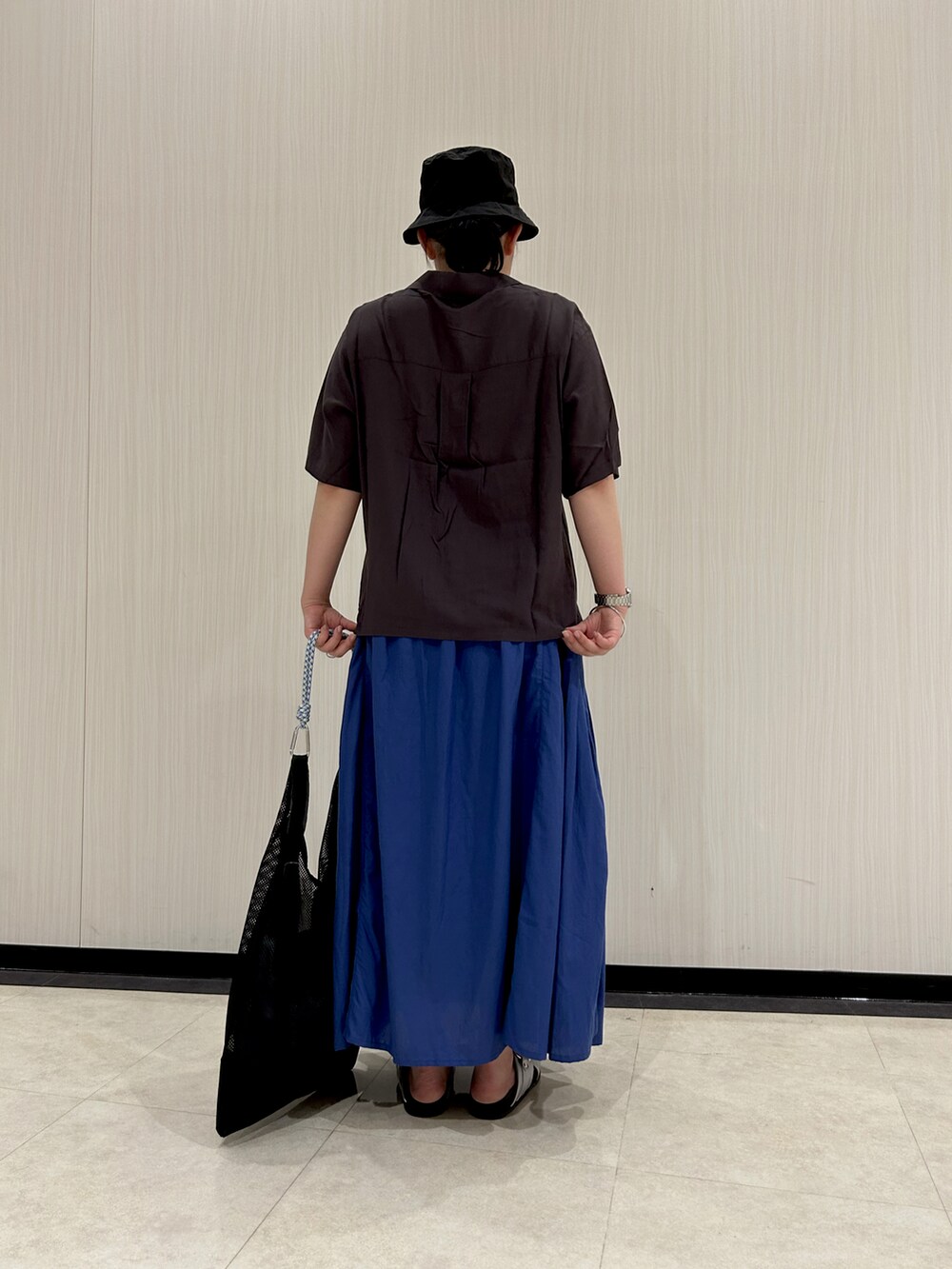 グレー系のシャツ/ブラウス、ブラック系のハンドバッグ、ブルー系のスカートを着用したレディースの夏コーディネートの4枚目の写真