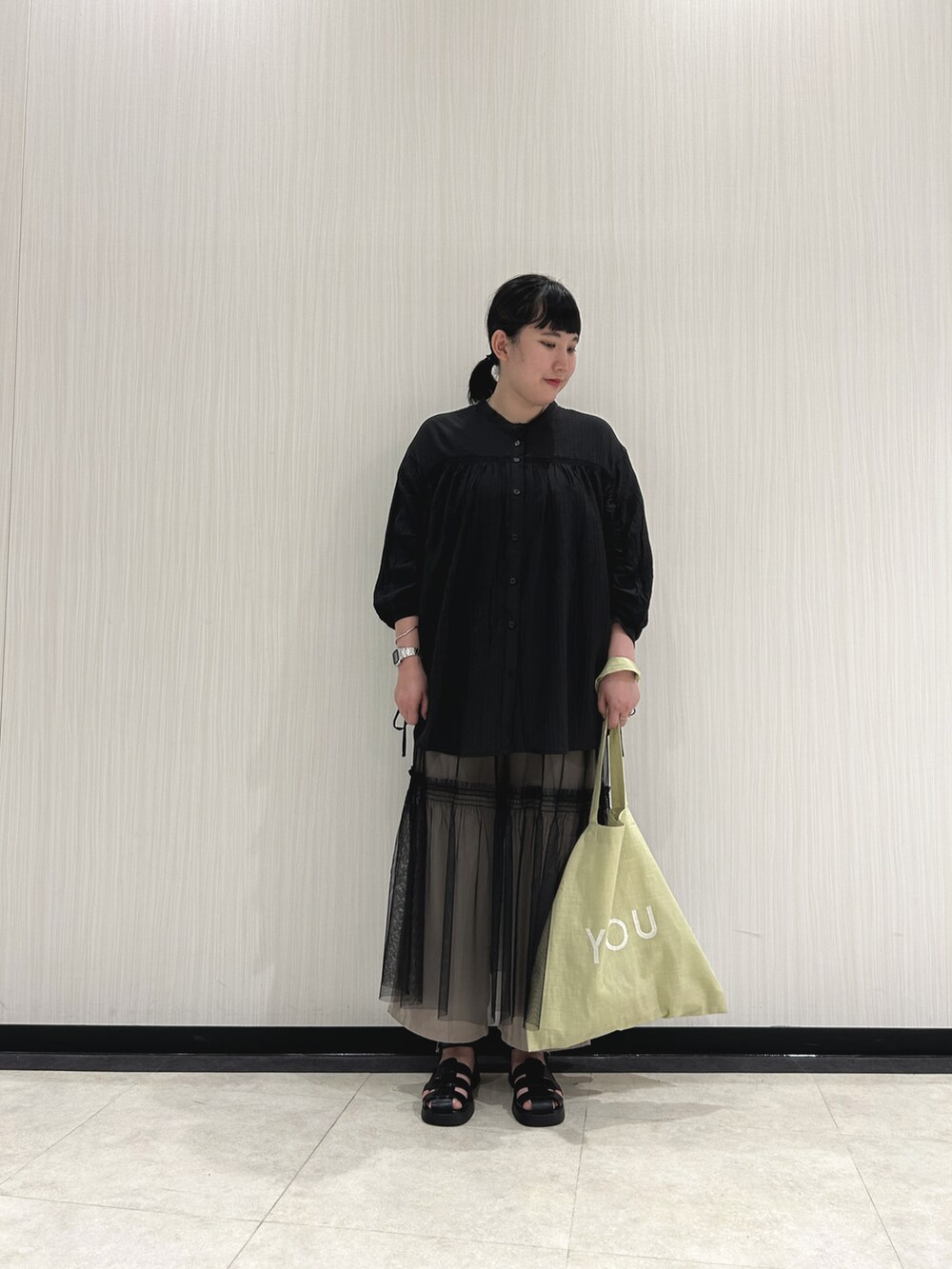 ブラック系のシャツ/ブラウス、ブラック系のスカート、ベージュ系のその他パンツを着用したレディースの春コーディネートの2枚目の写真