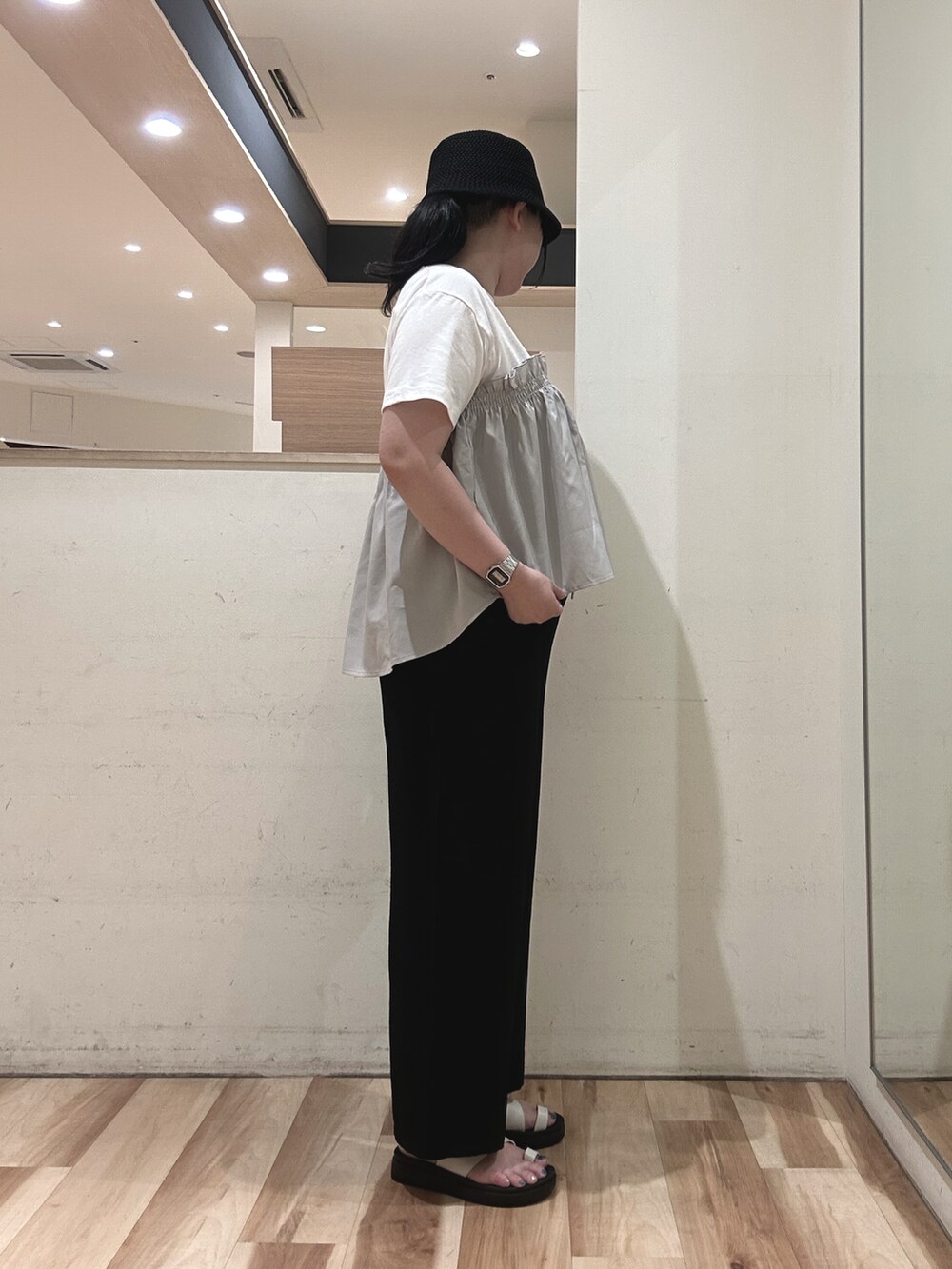 グレー系のTシャツ/カットソー、ブラック系のハンドバッグ、ベージュ系のドレスシューズを着用したレディースの春コーディネートの2枚目の写真