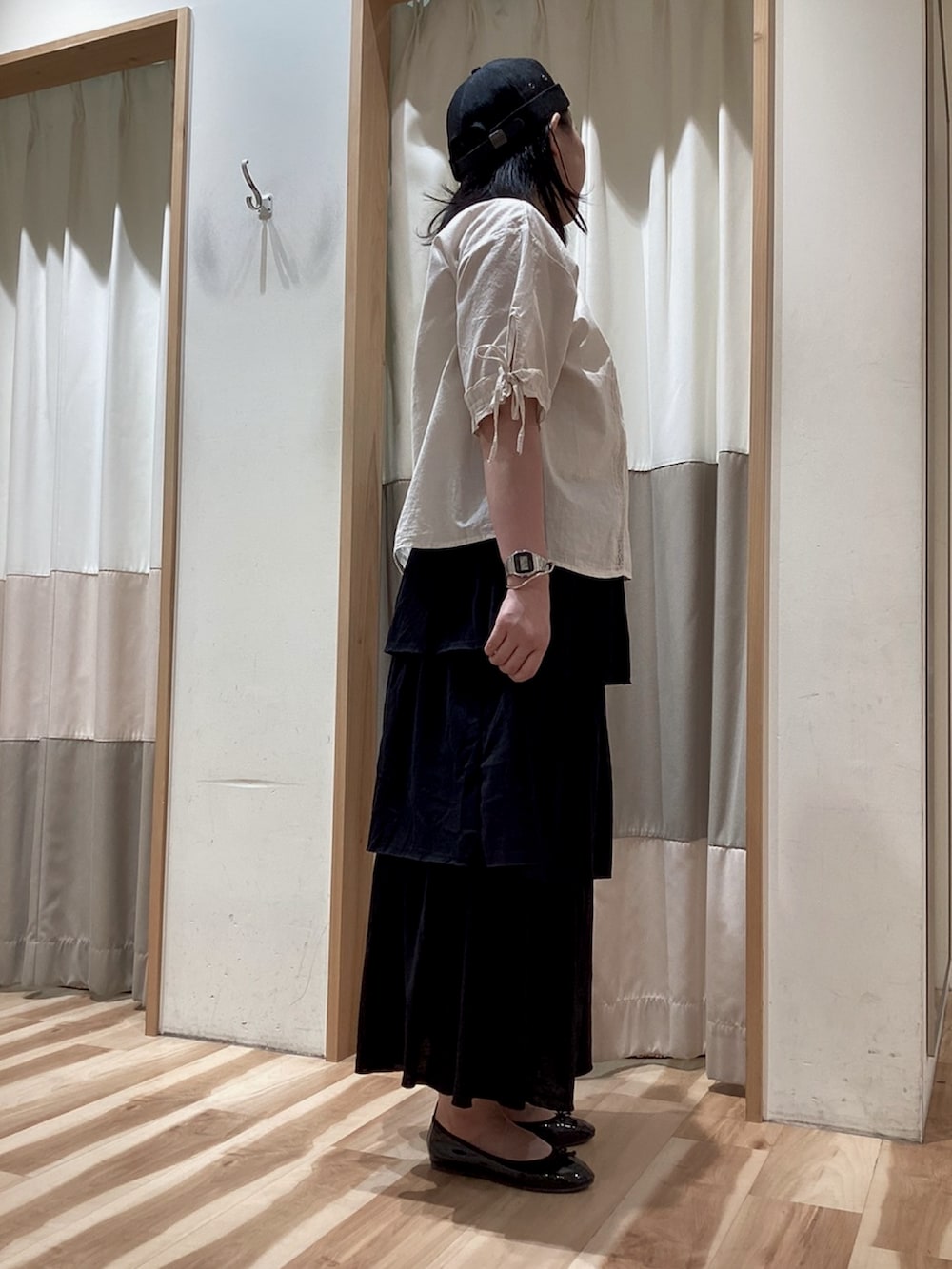 ブラック系のスカート、ホワイト系のシャツ/ブラウス、ブラック系のパンプスを着用したレディースの夏コーディネートの2枚目の写真