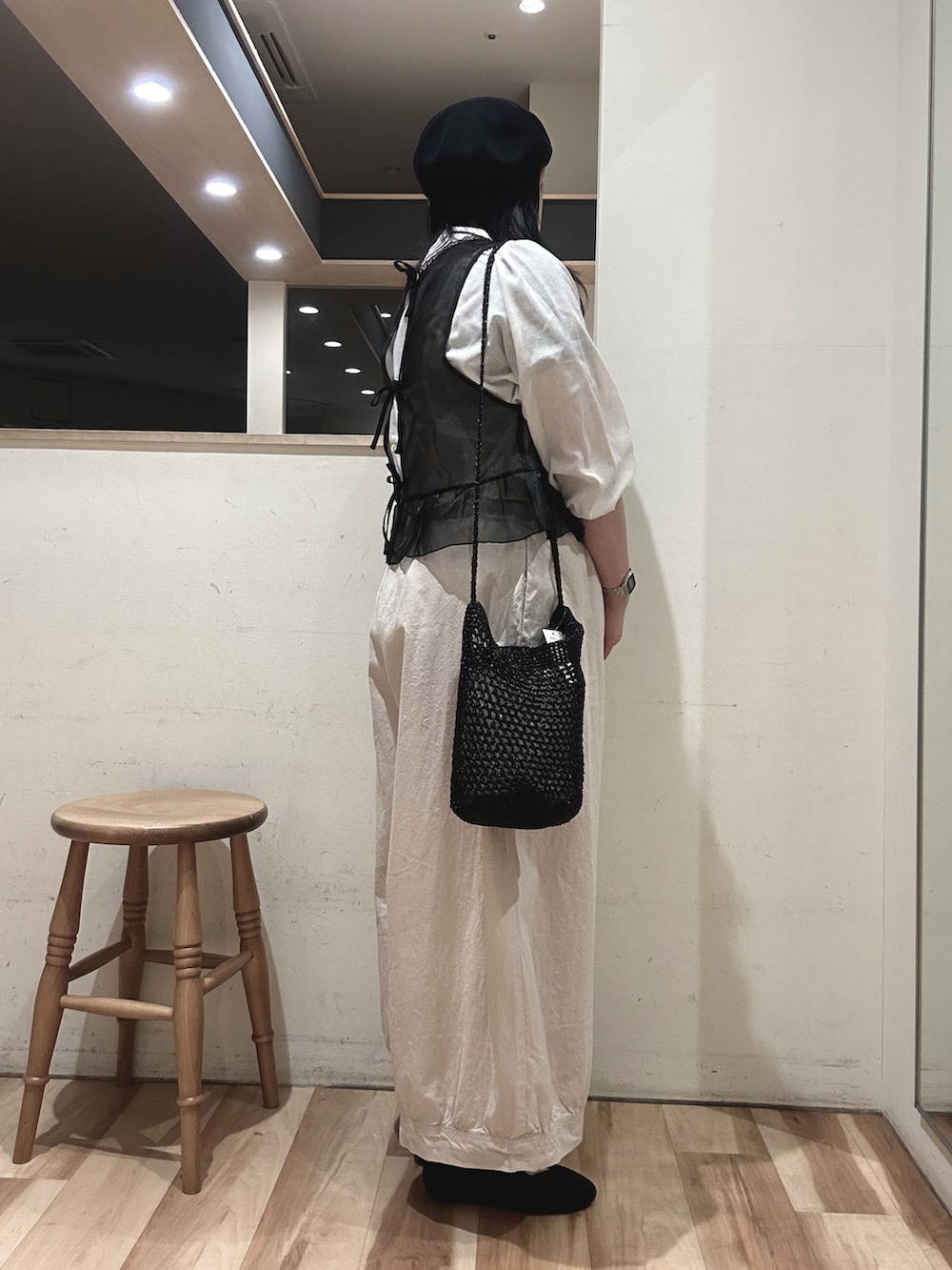 ブラック系のベスト、ホワイト系のその他パンツ、ブラック系のハンドバッグを着用したレディースの春コーディネートの2枚目の写真