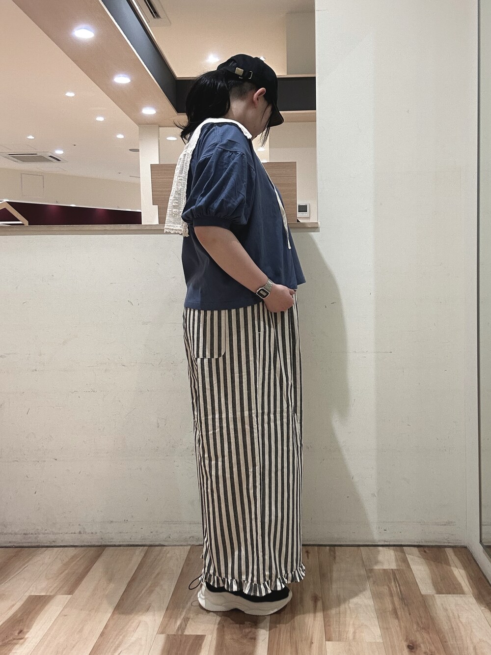 ブルー系のTシャツ/カットソー、ブラック系のスニーカー、ベージュ系のその他パンツを着用したレディースの春コーディネートの2枚目の写真