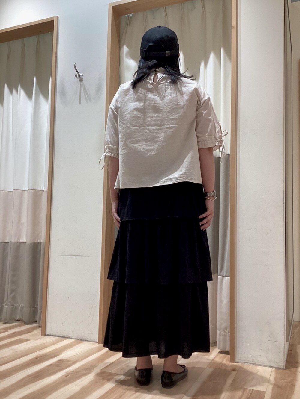 ブラック系のスカート、ホワイト系のシャツ/ブラウス、ブラック系のパンプスを着用したレディースの夏コーディネートの4枚目の写真