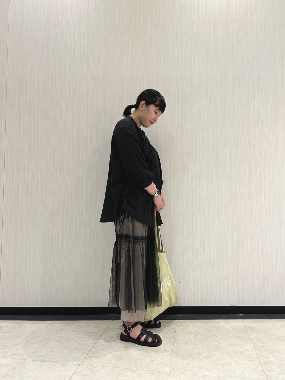 ブラック系のシャツ/ブラウス、ブラック系のスカート、ベージュ系のその他パンツを着用したレディースの春コーディネートの3枚目の写真