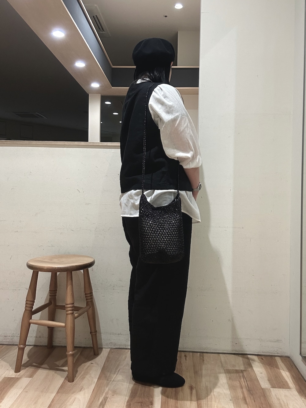 ブラック系のハンドバッグ、ブラック系のベスト、ホワイト系のシャツ/ブラウスを着用したレディースの春コーディネートの2枚目の写真