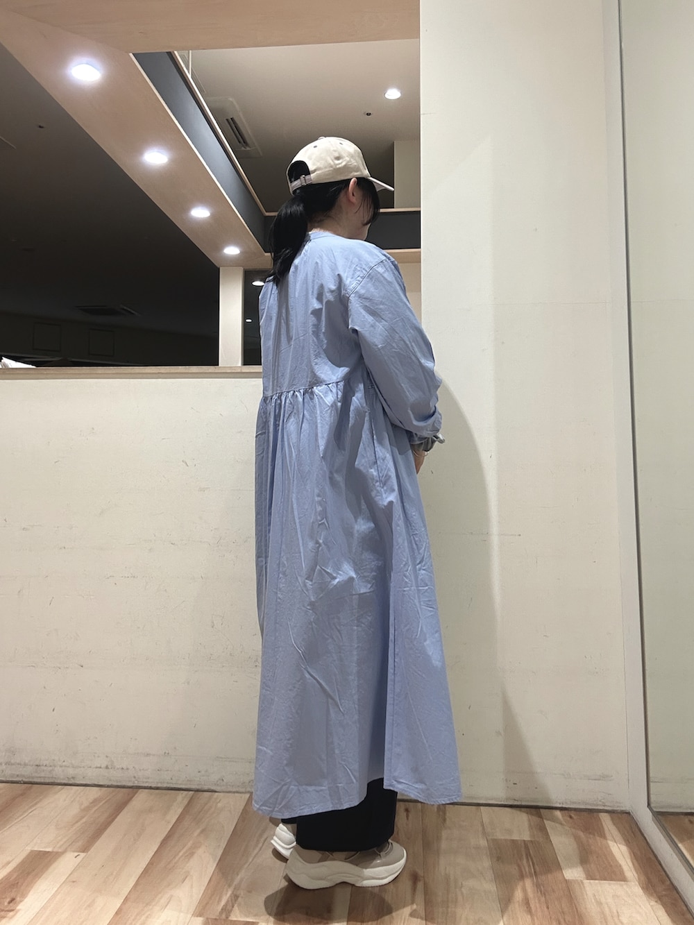 ベージュ系のスニーカー、ブルー系のハンドバッグ、ブルー系のワンピースを着用したレディースの春コーディネートの2枚目の写真