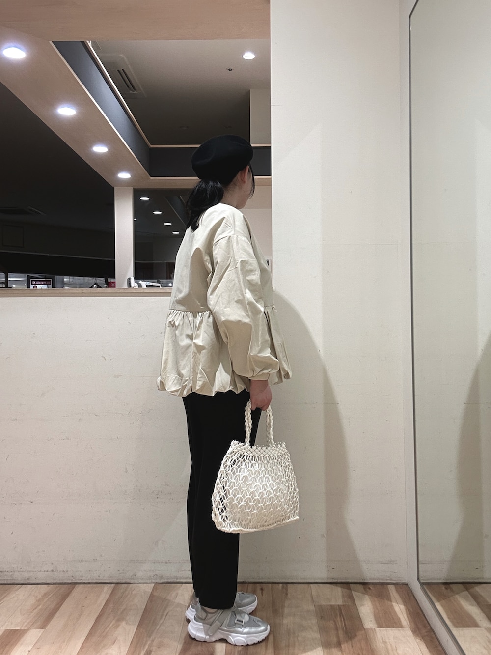 ベージュ系のブルゾン、ホワイト系のハンドバッグ、ブラック系のその他パンツを着用したレディースの春コーディネートの2枚目の写真