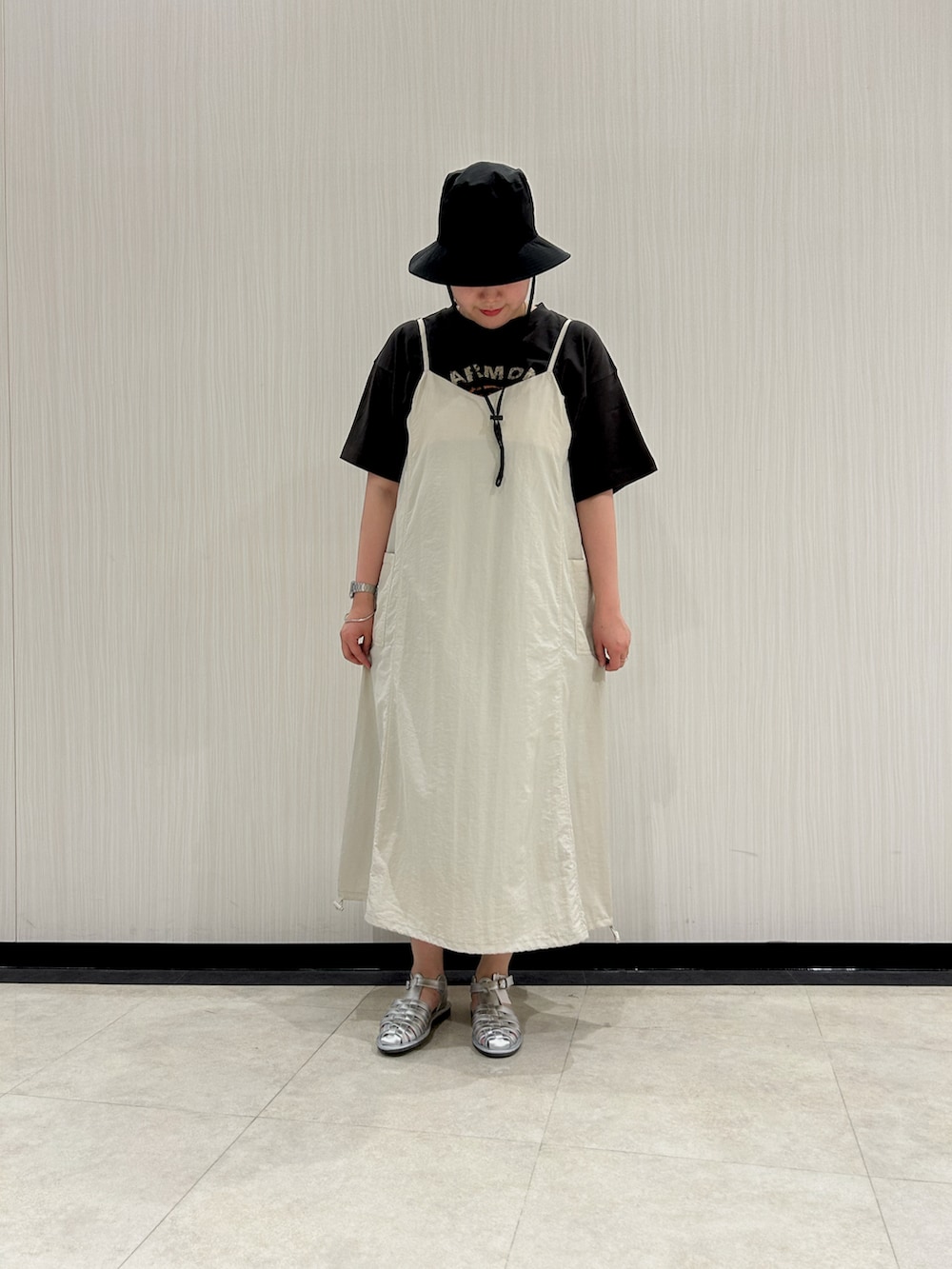 グレー系のTシャツ/カットソー、シルバー系のサンダル、ブラック系のハットを着用したレディースの夏コーディネートの2枚目の写真