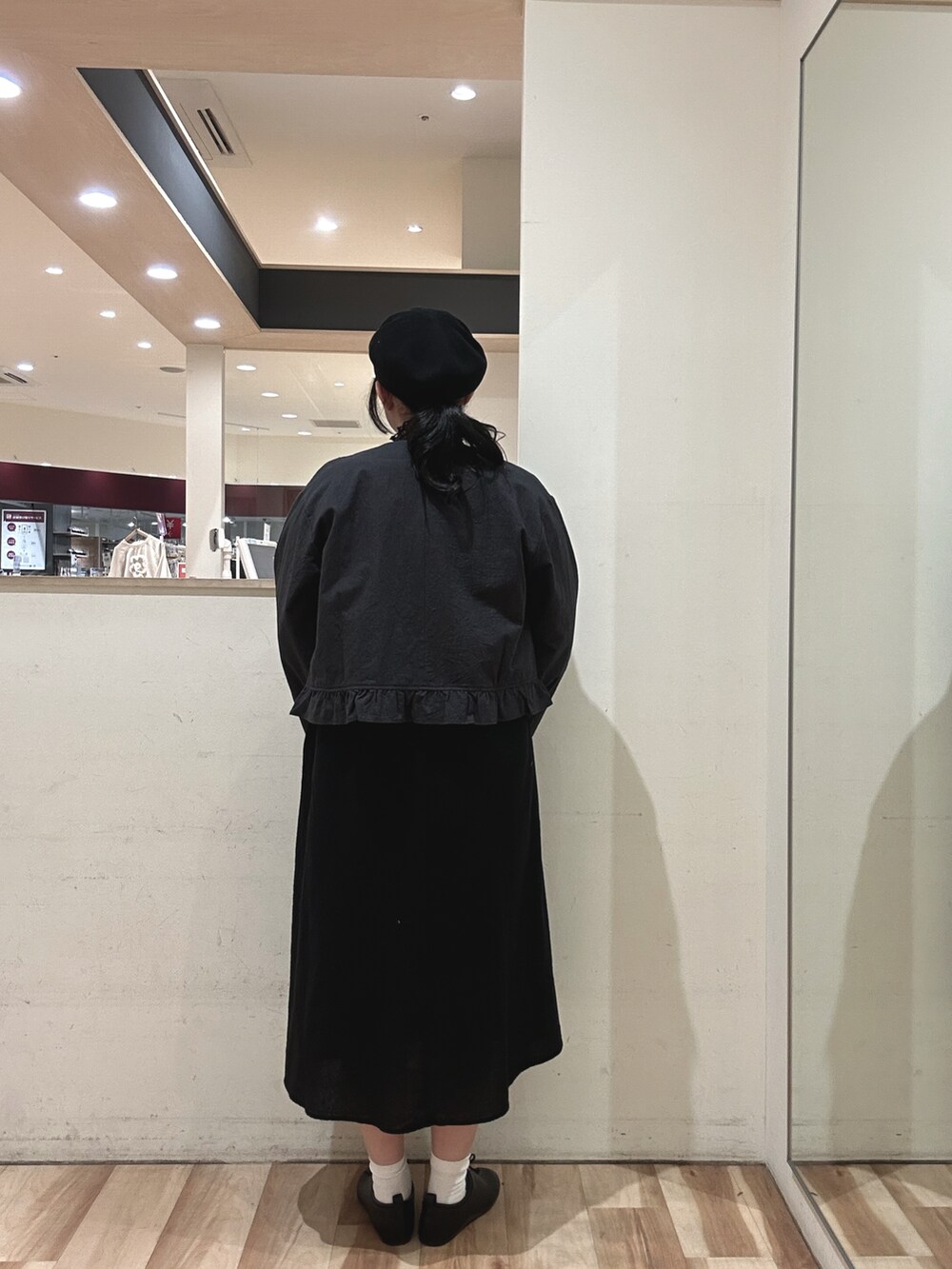 ブラック系のドレスシューズ、グレー系のノーカラージャケット、ブラック系のワンピースを着用したレディースの春コーディネートの3枚目の写真