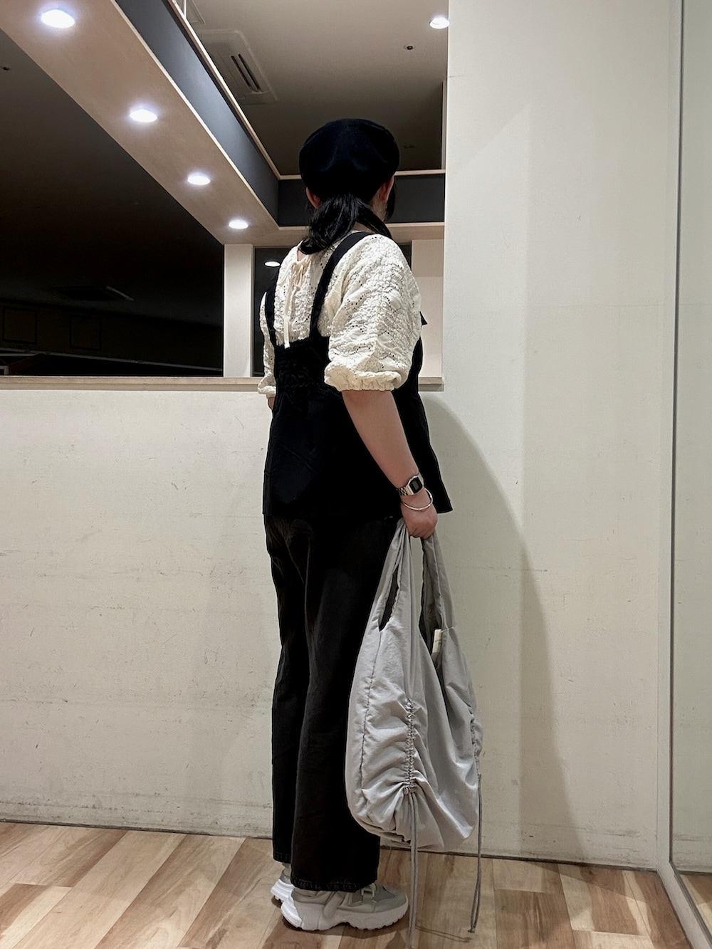 グレー系のハンドバッグ、シルバー系のドレスシューズ、ブラック系のシャツ/ブラウスを着用したレディースの春コーディネートの2枚目の写真