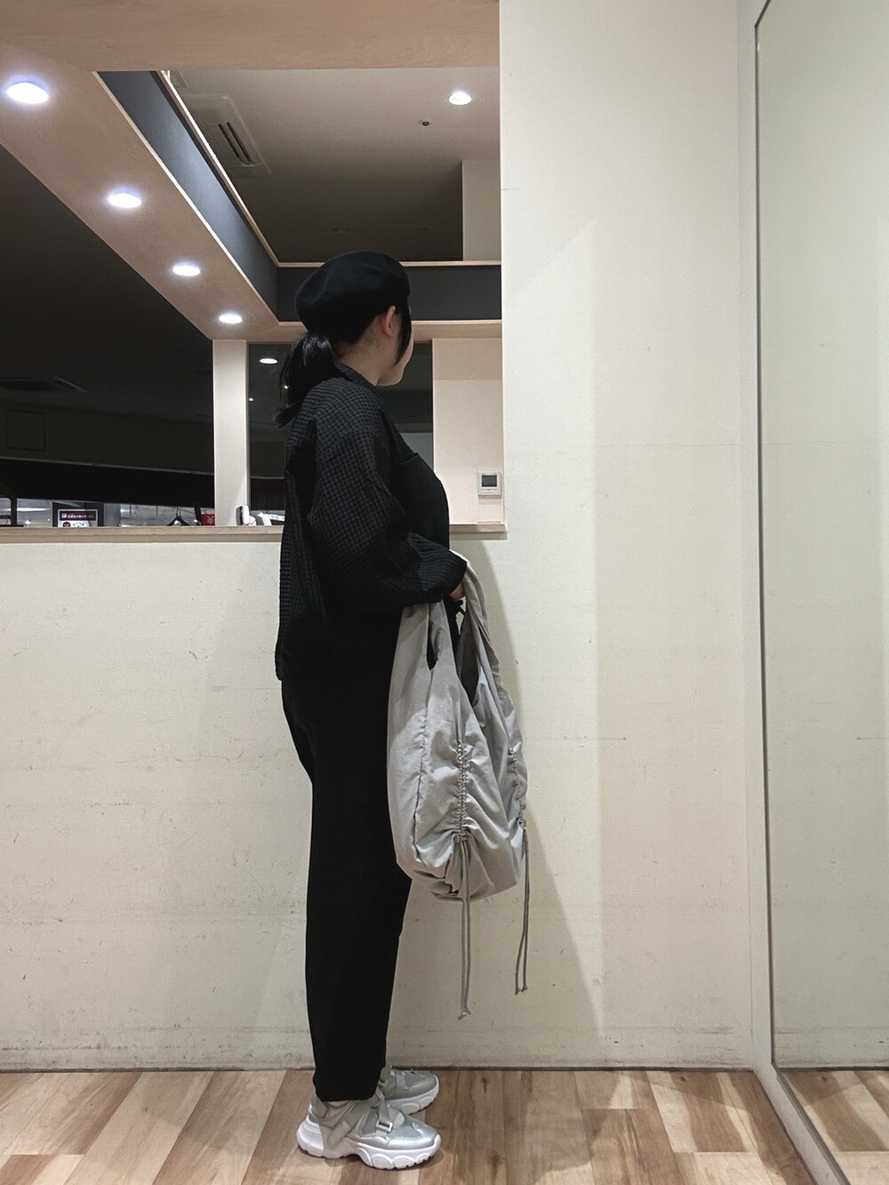 グレー系のハンドバッグ、ブラック系のその他パンツ、シルバー系のドレスシューズを着用したレディースの春コーディネートの2枚目の写真