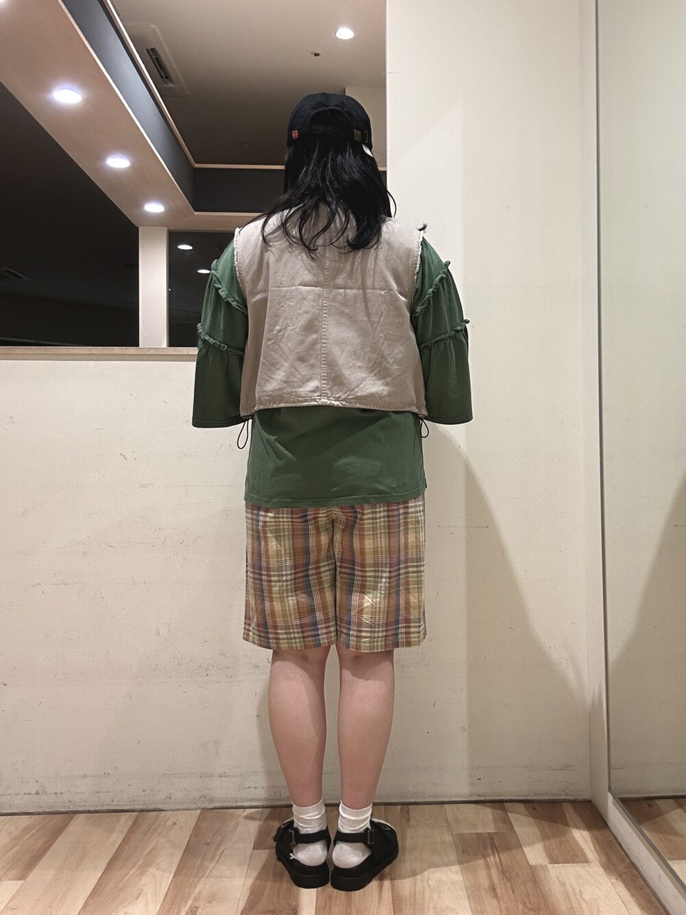 オレンジ系のその他パンツ、グリーン系のTシャツ/カットソー、グレー系のベストを着用したレディースの春コーディネートの3枚目の写真