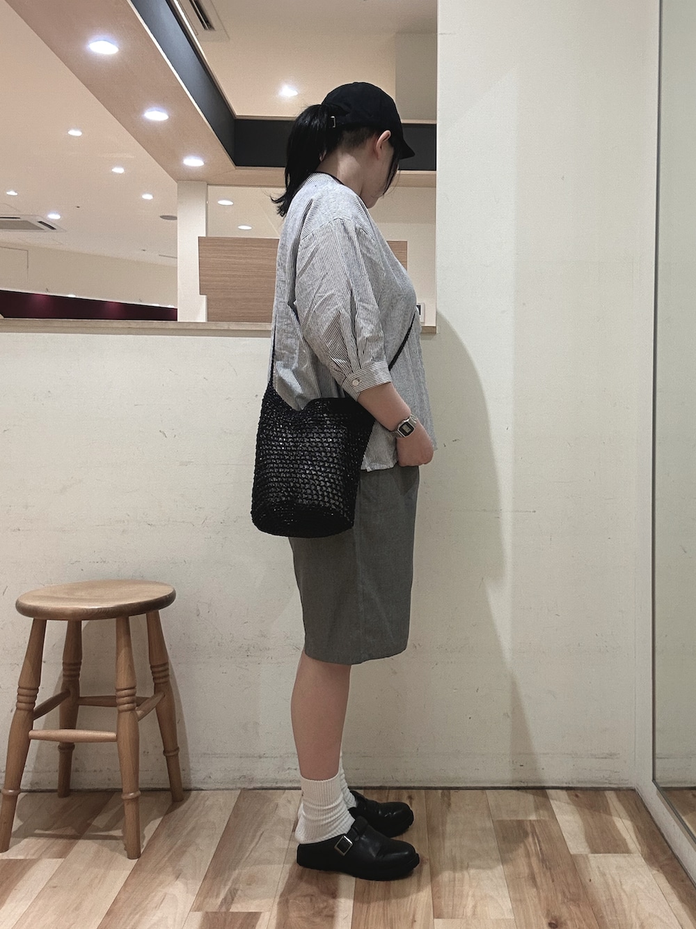 ブラック系のドレスシューズ、ブラック系のハンドバッグ、ブルー系のシャツ/ブラウスを着用したレディースの春コーディネートの2枚目の写真